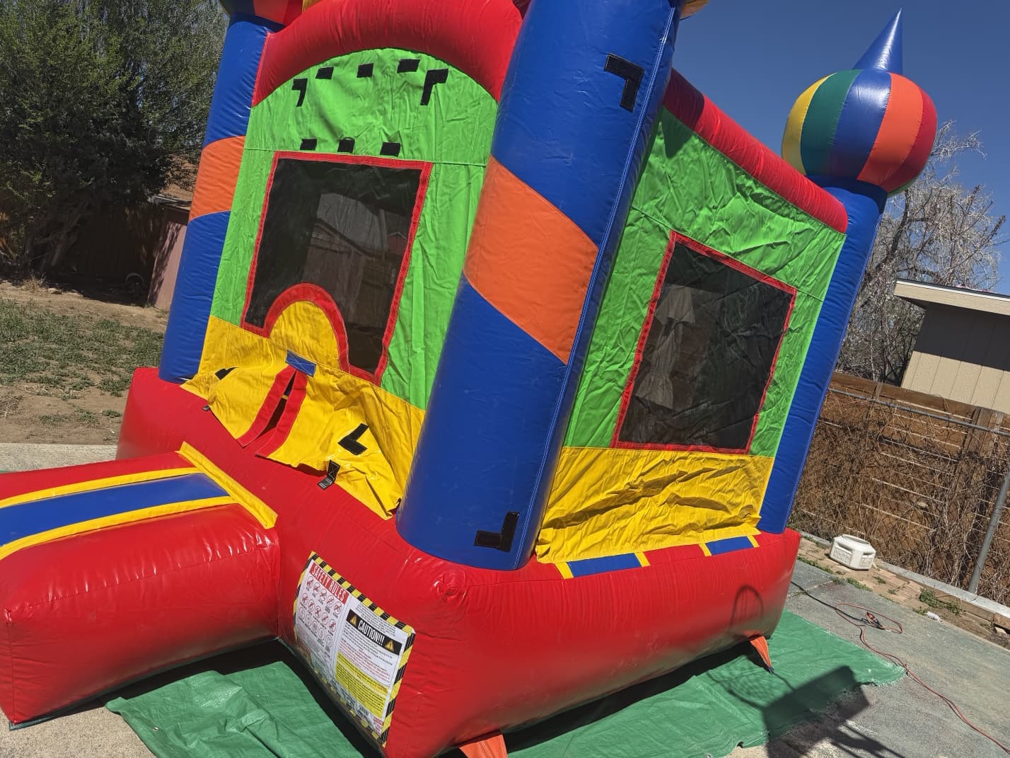 Green, red, and yellow combo bounce house with slide